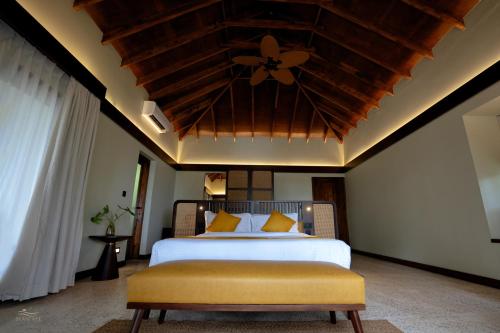 a bedroom with a large bed with a wooden ceiling at Seascape Beach Retreat in Kannur