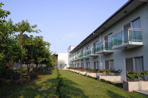 an apartment building with a lawn in front of it at Luganvilla Business Hotel and Restaurant in Luganville