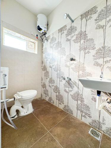 a bathroom with a toilet and a sink at Redfox Service Apartment - Ambattur in Jāmb