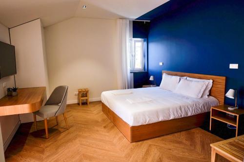 a bedroom with a large bed with a blue wall at Mid-Atlantic House in Angra do Heroísmo