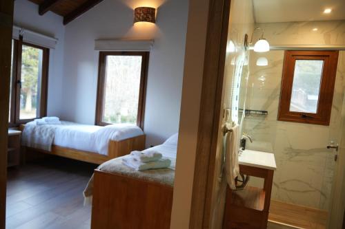 a bathroom with a shower and a bed and a sink at Guti Andino Boutique in San Carlos de Bariloche