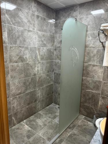 a shower with a glass door in a bathroom at ANKARA EFEs OTEL in Altındağ