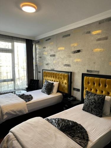 a bedroom with two beds and a wall with graffiti at ANKARA EFEs OTEL in Altındağ