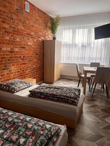 a room with two beds and a brick wall at apartament in Skarżysko-Kamienna