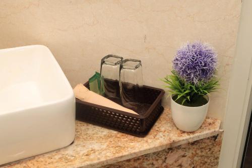 a counter with two glass jars and a plant on it at Hugo Hotel in Phú Quốc