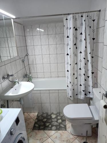 a bathroom with a sink and a toilet and a tub at Apartamenty na skarpie in Szczecin