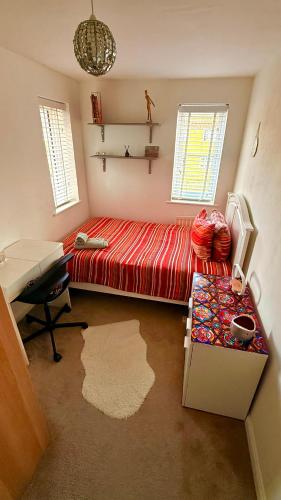 a bedroom with a red bed and a desk at Private room in BS14 in Bristol