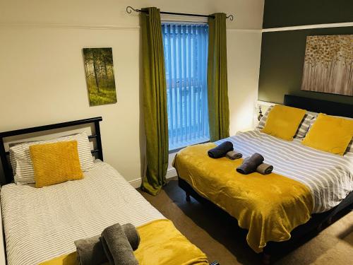 a bedroom with two beds and a window at Ideal 2 bed pay-as-you-stay home in Widnes sleeps 5 in Halton