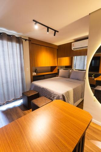 a hotel room with a bed and a table at Flat Exclusivo Studio Cuiabá 1604 in Cuiabá