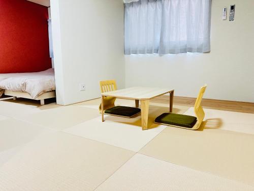 a room with a table and two chairs and a bed at MA House Osaka Japan Apartment in Osaka
