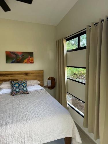 a bedroom with a bed and a window at Casa Rio Tortuga - Colibri in Tortugal