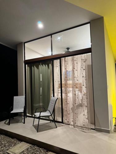 two chairs sitting in a room with glass doors at Casa Rio Tortuga - Butterfly in Ojochal