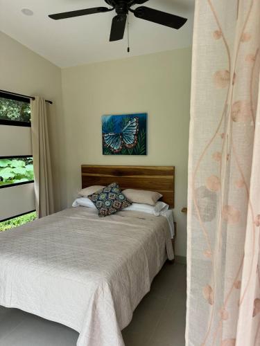 a bedroom with a bed and a ceiling fan at Casa Rio Tortuga - Butterfly in Ojochal