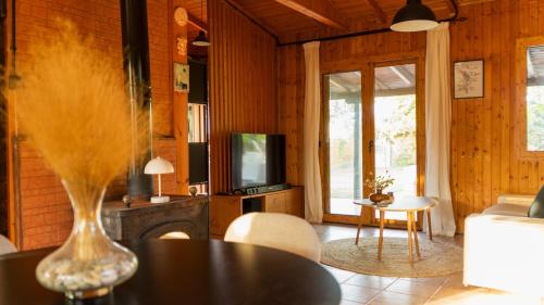 a living room with a couch and a table and a tv at Casa Mocha by RentalsPro - Vourvourou Halkidiki in Vourvourou