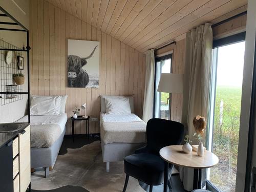 a room with two beds and a table with a desk at Studio op Camperplaats Vechtdal in Nieuwleusen