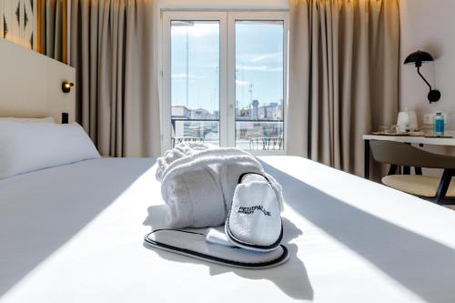 a hotel room with a bed with a hat on it at Petit Palace Plaza de la Reina in Valencia