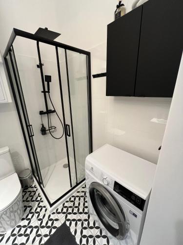a washing machine in a bathroom with a shower at Old Town Rynek Apartament in Grudziądz