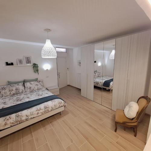 a bedroom with a bed and a chair and a mirror at Elunà Assisi Home in Assisi