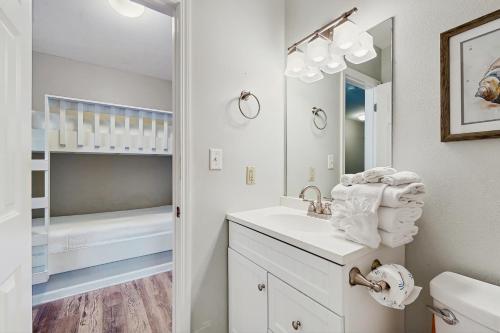 a white bathroom with a sink and a crib at Grand Caribbean 104 in Orange Beach