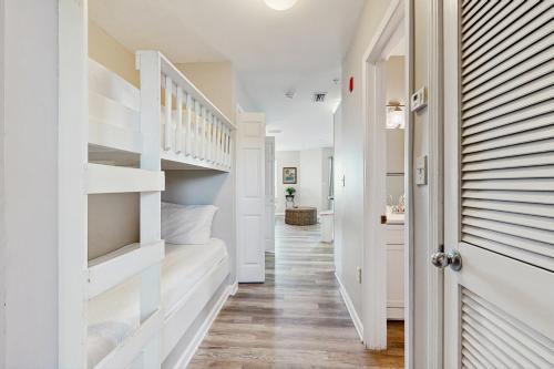a hallway with white walls and a white stair case at Grand Caribbean 104 in Orange Beach
