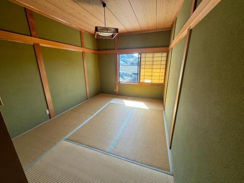 an empty room with a window in a room at ゲストハウス虎のいえ in Sukumo