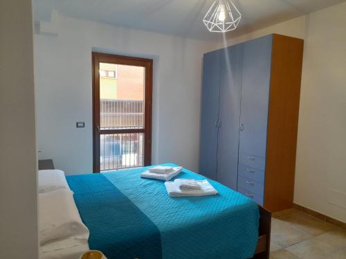a bedroom with a blue bed with two towels on it at Casa Molines in Giaveno