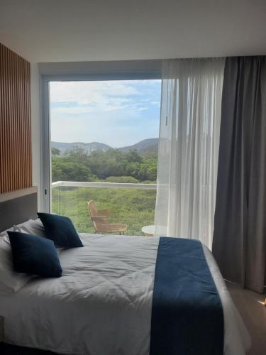 a bedroom with a bed and a large window at Porto Horizonte suite 424 in Playa Bello Horizonte