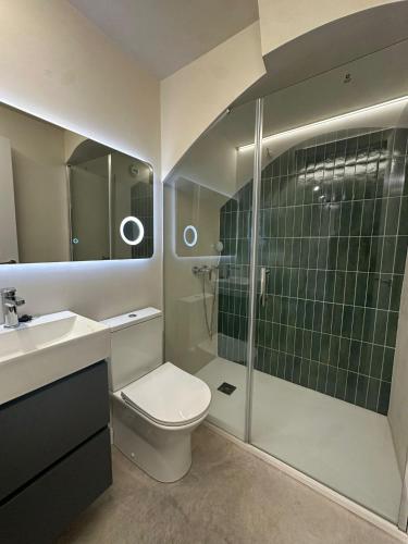 a bathroom with a toilet and a glass shower at Sol Mediterráneo - Palm City 2 in Elche