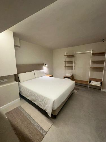 a bedroom with a large white bed and shelves at Sol Mediterráneo - Palm City 2 in Elche