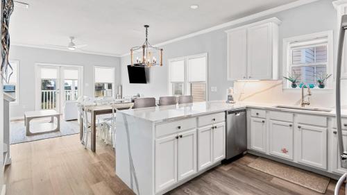 a kitchen with white cabinets and a dining room at Salty Seabreeze in Seacrest