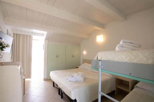 ein Schlafzimmer mit zwei Betten, auf denen Handtücher liegen. in der Unterkunft Hotel Lara in Riccione