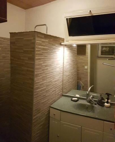 un bagno con lavandino e specchio di Kaz' d'Ô a Étang-Salé les Bains