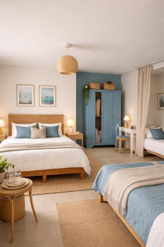 una camera da letto con due letti e una parete blu di LE PRESBYTERE a Rouperroux-le-Coquet