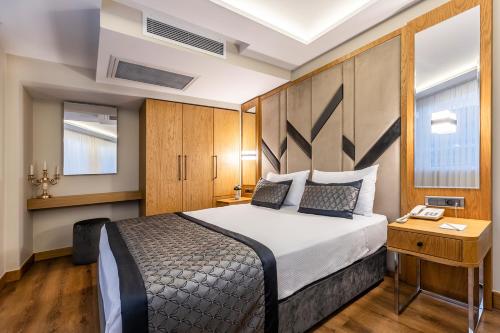 a hotel room with a bed and a desk with a phone at Sultanahmet Newport Hotel in Istanbul