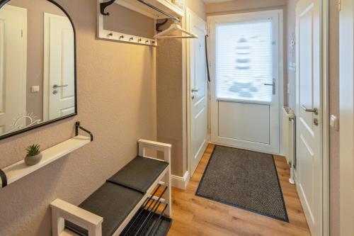 a hallway with a treadmill and a mirror and a door at Küstenkoje in Neßmersiel