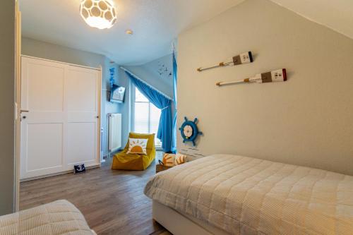 a bedroom with a bed and a room with blue walls at Küstenkoje in Neßmersiel