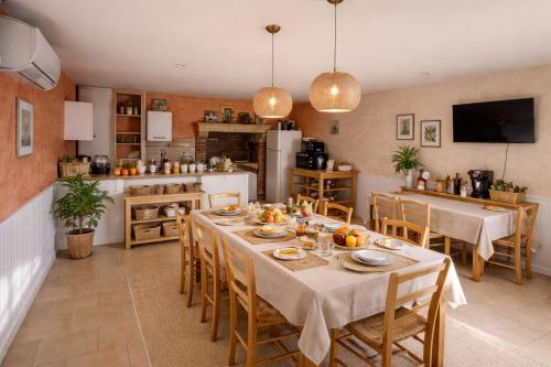 una sala da pranzo con tavolo e cucina di LE PRESBYTERE a Rouperroux-le-Coquet
