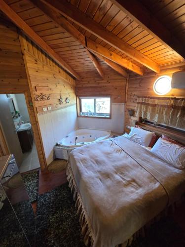 a bedroom with a large bed and a bath tub at Among the cherry trees B&B 6 - Nahal Dan in Metulla