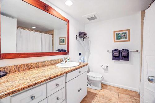 a bathroom with a sink and a toilet and a mirror at Islander on the Beach 131 in Kapaa