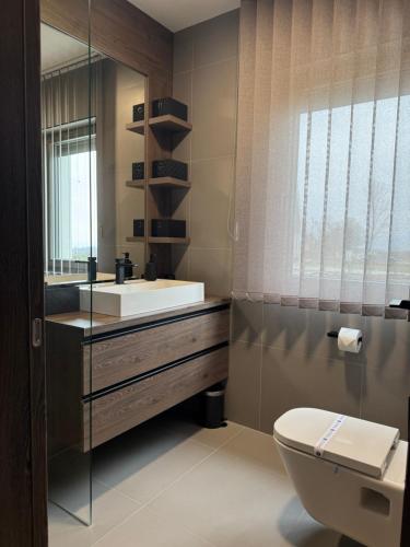 a bathroom with a sink and a toilet and a mirror at BODU Vendégház in Balatonberény