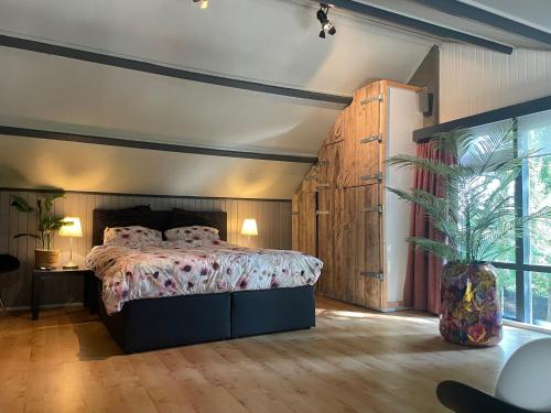 a bedroom with a bed and a large window at heerlijk-huisje in Zandschel
