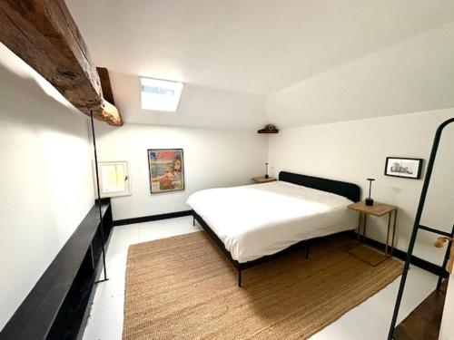 a bedroom with a white bed and a wooden floor at Villa Paignon Gite in Montbron