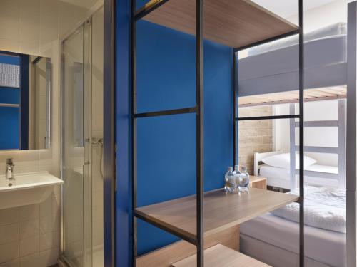 a bathroom with a bunk bed and a sink at Hostel Link in Lovran