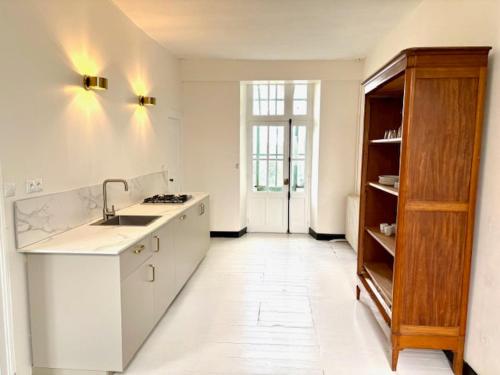 a large white kitchen with a sink and a counter at Villa Paignon Gite in Montbron
