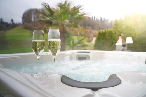 two glasses of champagne sitting on a bath tub at Residenza San Remy Hundefreundliche Ferienwohnung mit Whirlpool in Unterkulm
