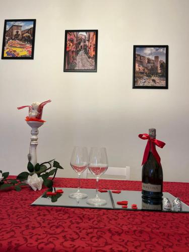 a table with two wine glasses and a bottle of wine at Il Nido in Spello
