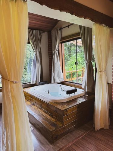 a bath tub in a room with a window at Pousada Sons do Silêncio in Socorro