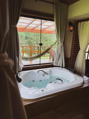 a large bath tub in a room with a window at Pousada Sons do Silêncio in Socorro
