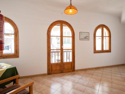 a room with a wooden door and three windows at ELIZA Skiathos in Skiathos Town