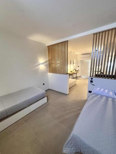 a white room with a bed and a desk at Little Kamara Ios in Ios Chora